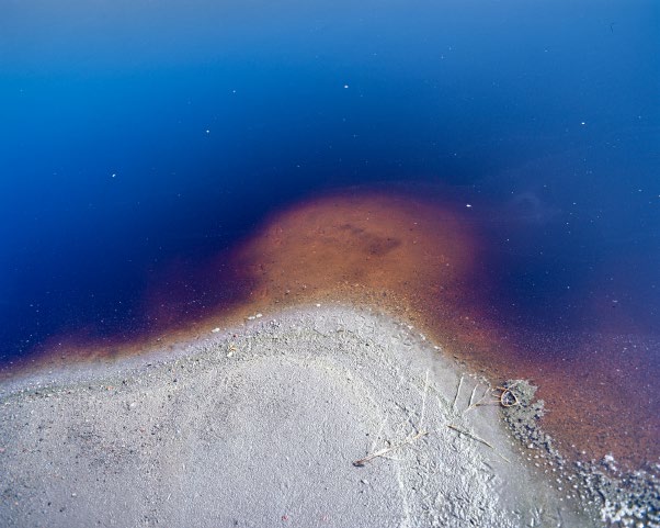 Fotografía aérea de un cuerpo de agua con sedimentos y estructuras