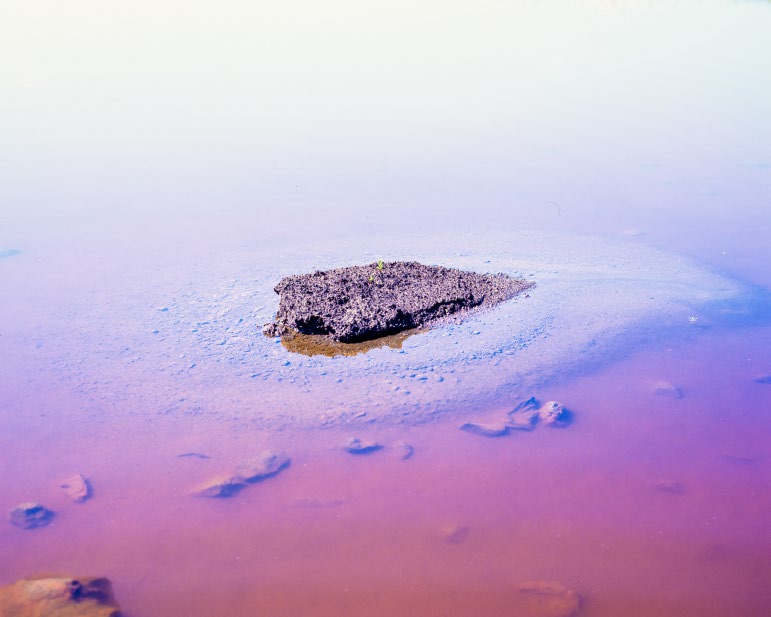 Pequeña isla oscura en un cuerpo de agua salina y poco profunda